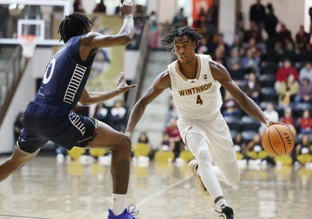 Winthrop University's Pharrell Boyogueno heads to the basket around Queens University's Jordan Watford on Nov. 3, 2025, at the Rock Hill Sports and Event Center.
