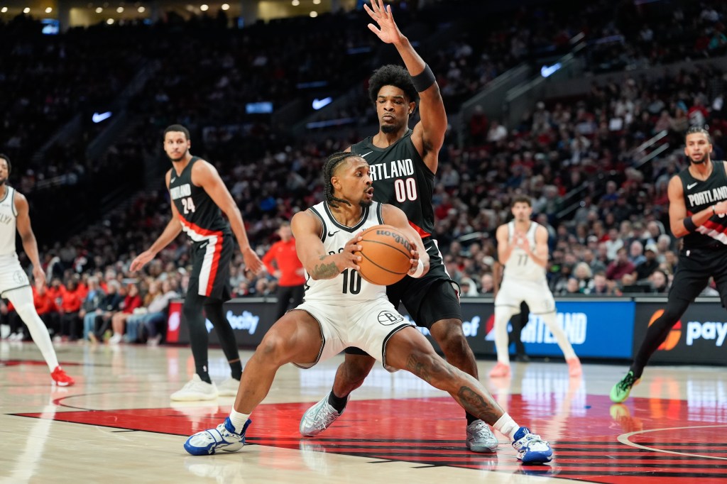 Nets guard Tyson Etienne (10) looks to get around Portland Trail Blazers guard Scoot Henderson (00) during the first half of an NBA basketball game Monday, March 23, 2026, in Portland, Ore.