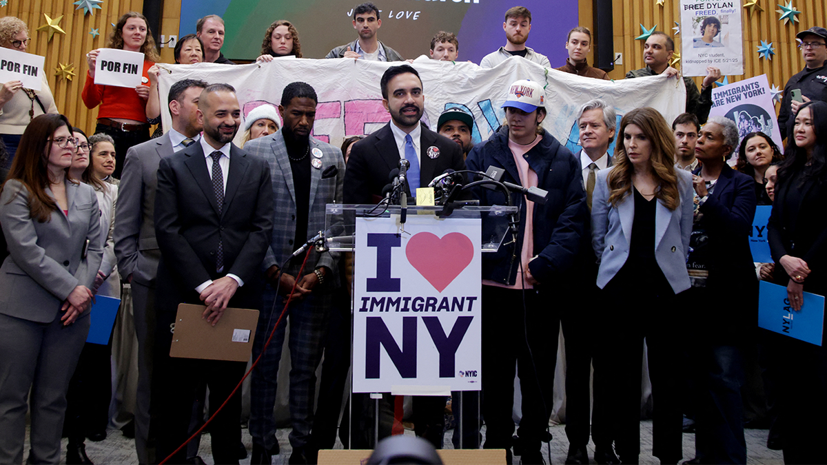 Zohran Mamdani speaking at a podium.