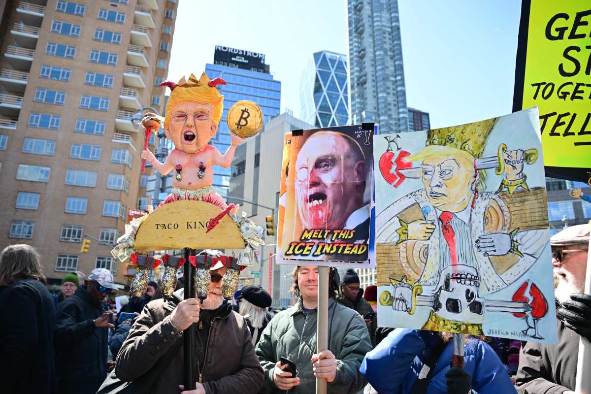 New Yorkers hold signs against President Trump during the "No Kings" march in Manhattan on March 28, 2026.