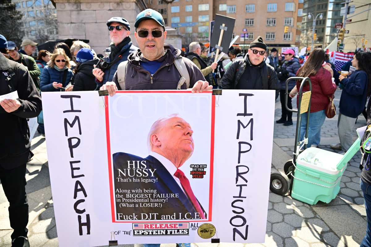 New Yorkers hold signs against President Trump during the "No Kings" march in Manhattan on March 28, 2026.