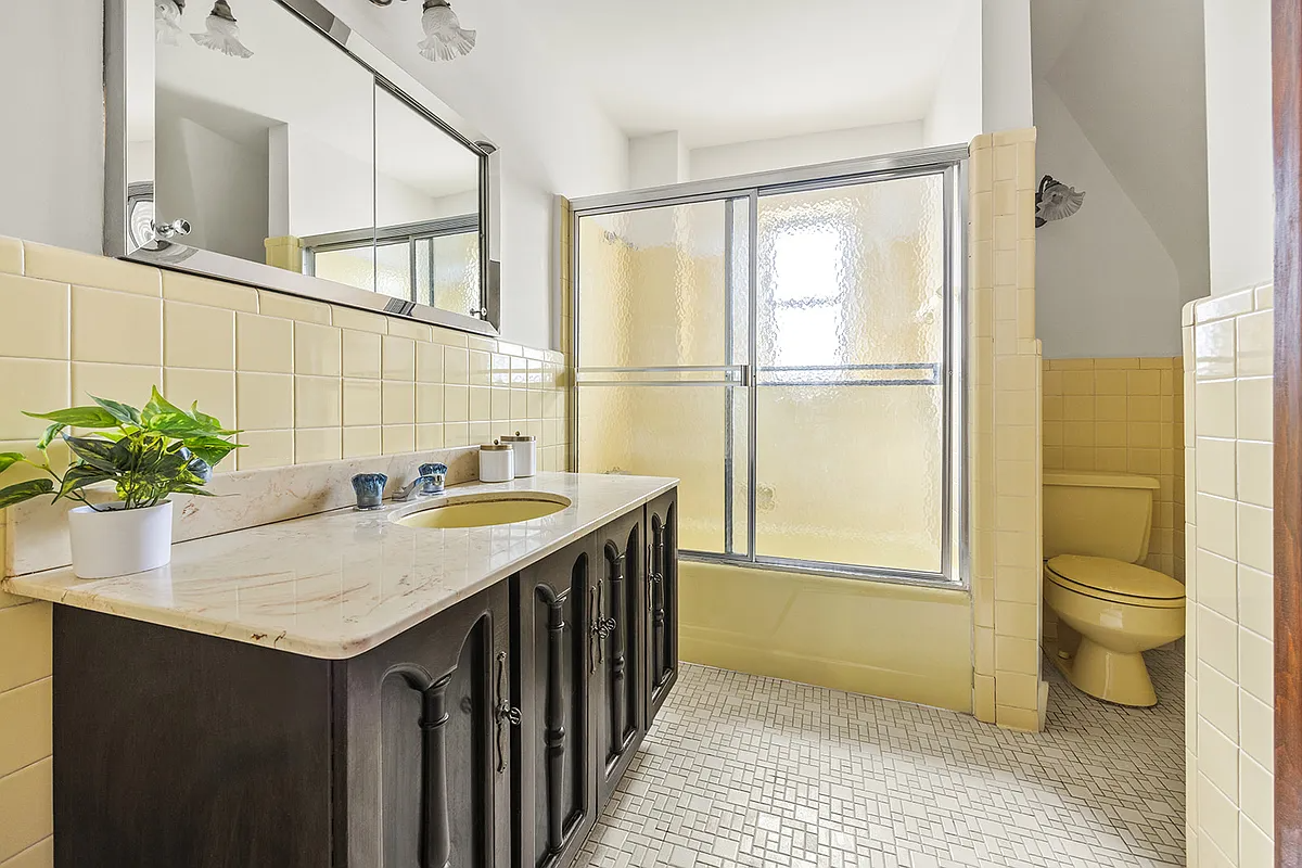 bathroom with vintage yellow tile, tub and toilet