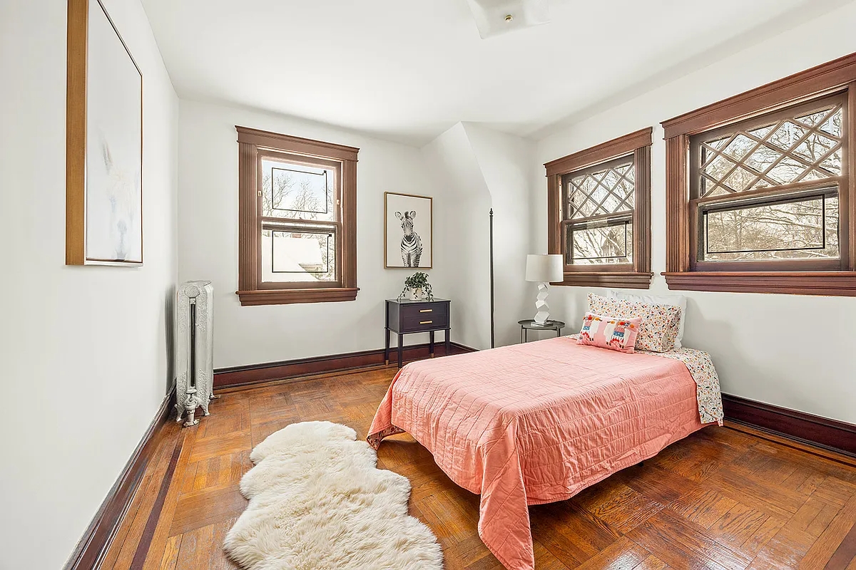 bedroom with wood floor, two exposures