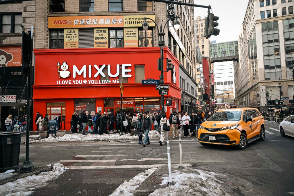 A Mixue coffee shop on Broadway in Koreatown, New York, with a long line of customers outside.