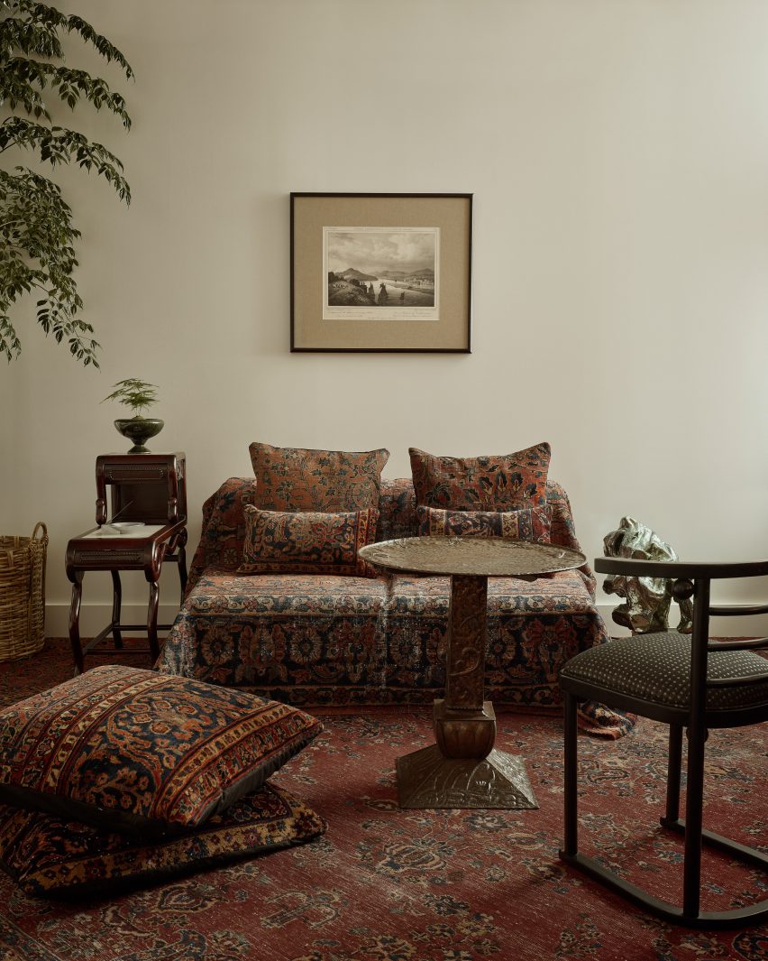 Antique Persian rugs cover the floor and furniture in an office space
