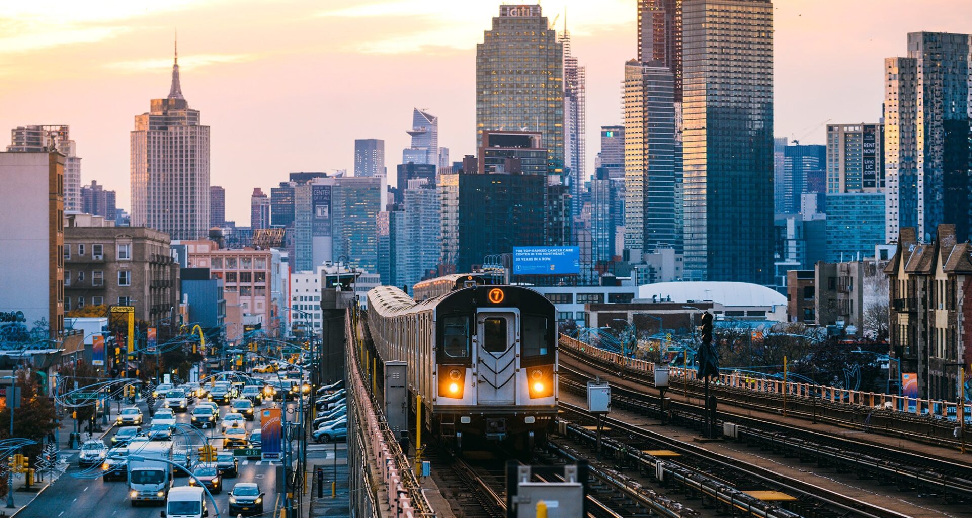 A subway train on the 7 line in Queens, with New York City's Manhattan skyline in the background.