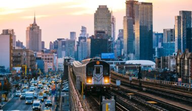 A subway train on the 7 line in Queens, with New York City's Manhattan skyline in the background.