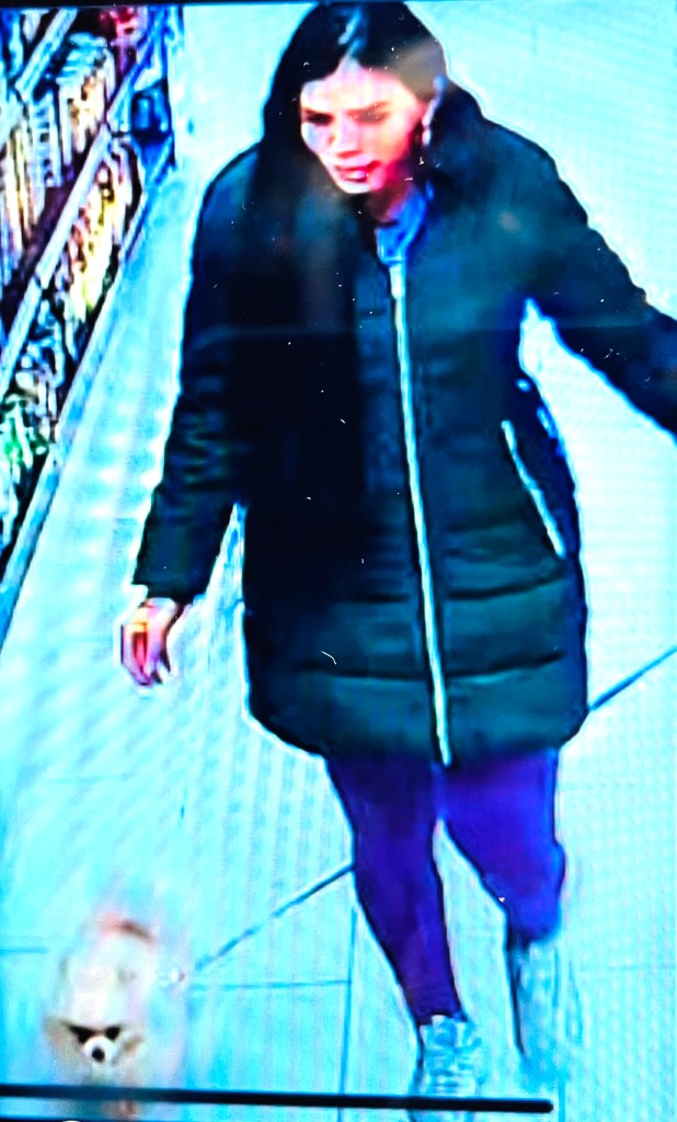 Surveillance camera image of Nicol Suarez in a black coat and purple pants.