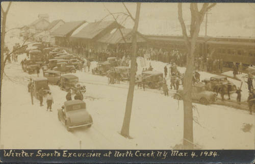 North Creek Depot lined with trains and cars as people prepare to head to the ski slopes from the Winter Sports Excursion Train.