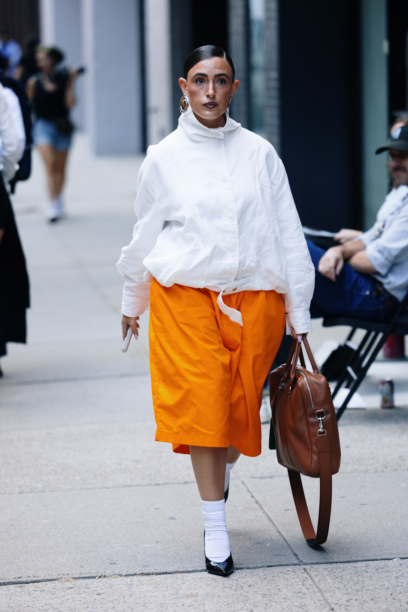 woman wearing orange sport shorts and a white jacket