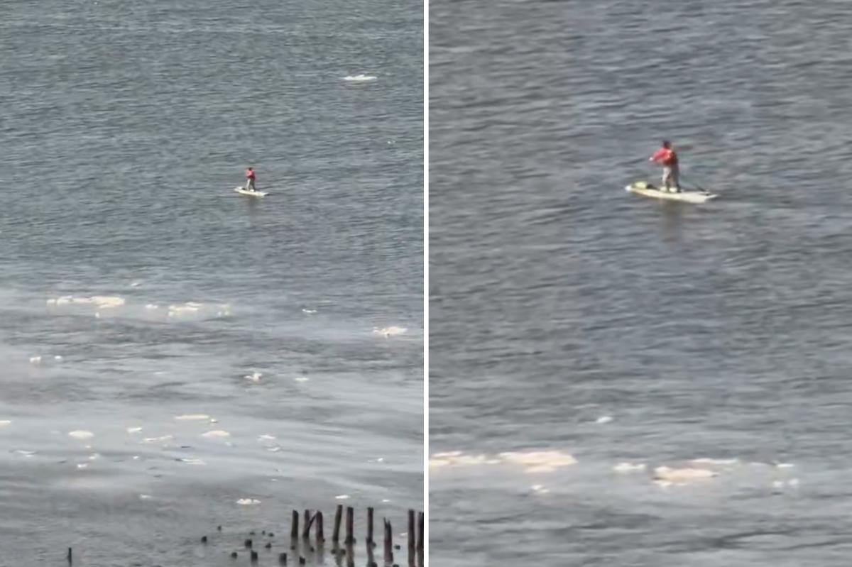 Paddleboarder wearing backpack cruises along the icy Hudson River: video