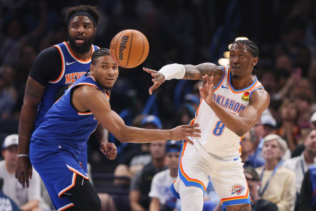 Oklahoma City Thunder guard Jalen Williams (8) passes the ball away from New York Knicks guard Miles McBride, front left, and center Mitchell Robinson, back left, during the first half.