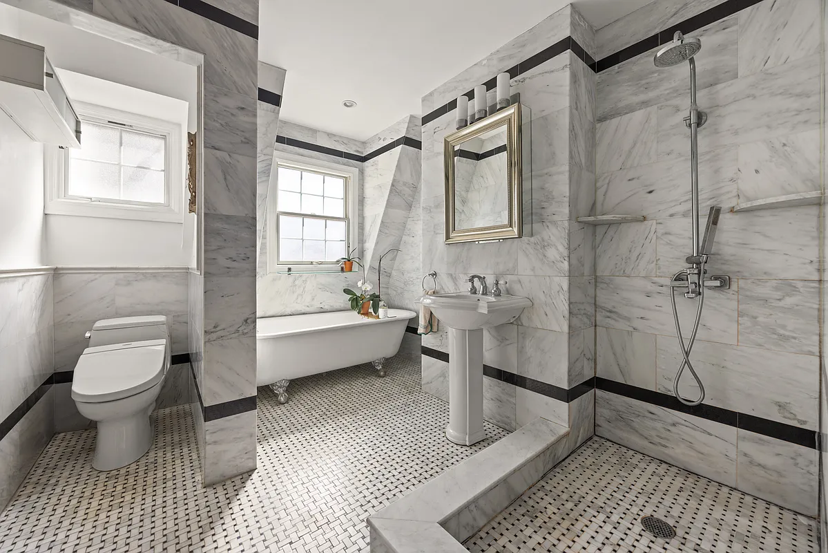 bathroom with marble tile, open shower, and a clawfoot tub