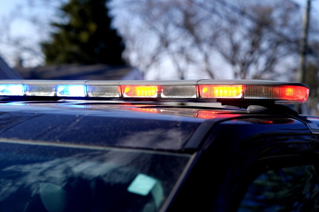 A police car's emergency light bar with flashing red and blue lights.