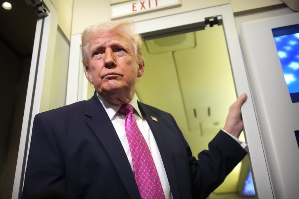 President Donald Trump speaks to reporters aboard Air Force One.