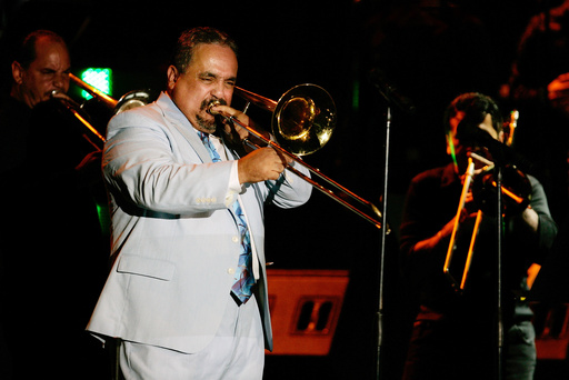 FILE - Willie Colon plays the trombone while performing the song "La Murga" during a tribute concert in honor of the late salsa music pioneer Hector Lavoe in San Juan, Puerto Rico, Sept. 7, 2007. Col&oacute;n, considered by many to be the "architect of urban salsa," died Saturday, Feb. 21, 2026. He was 75. (AP Photo/Andres Leighton, File)