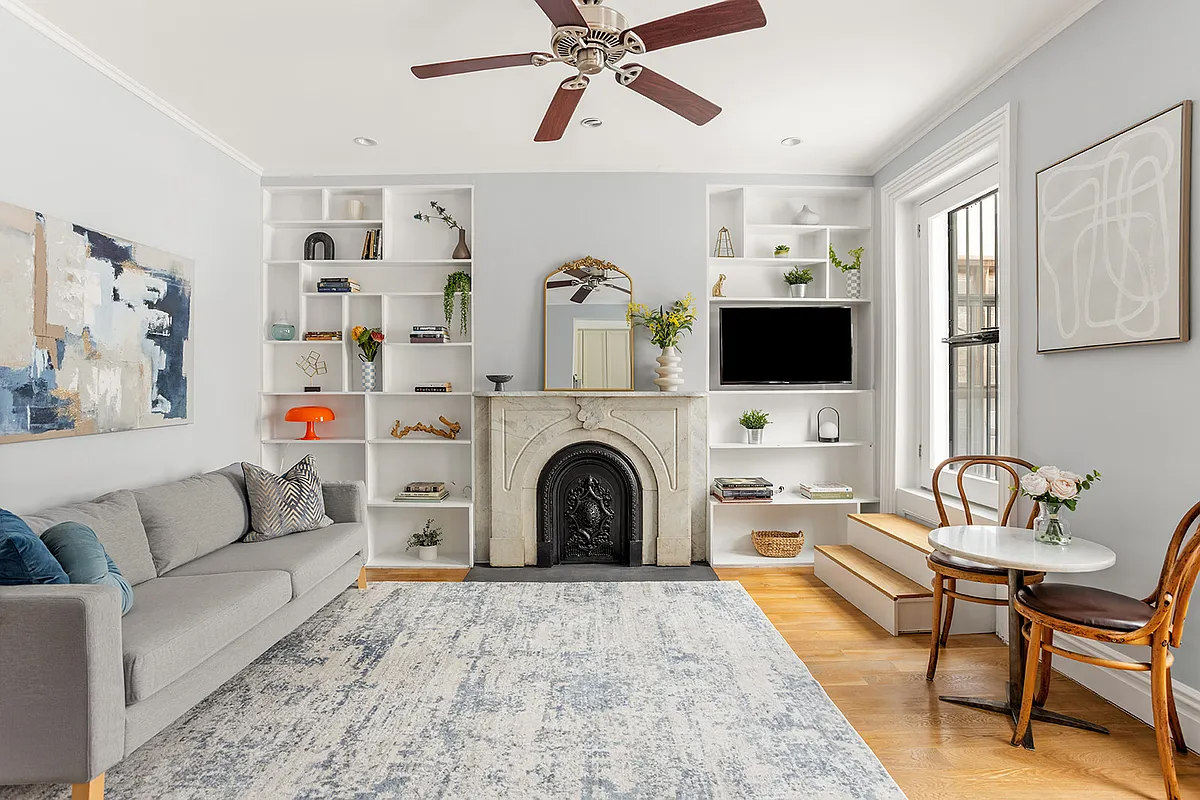 living room with built-ins on either side of a marble mantel