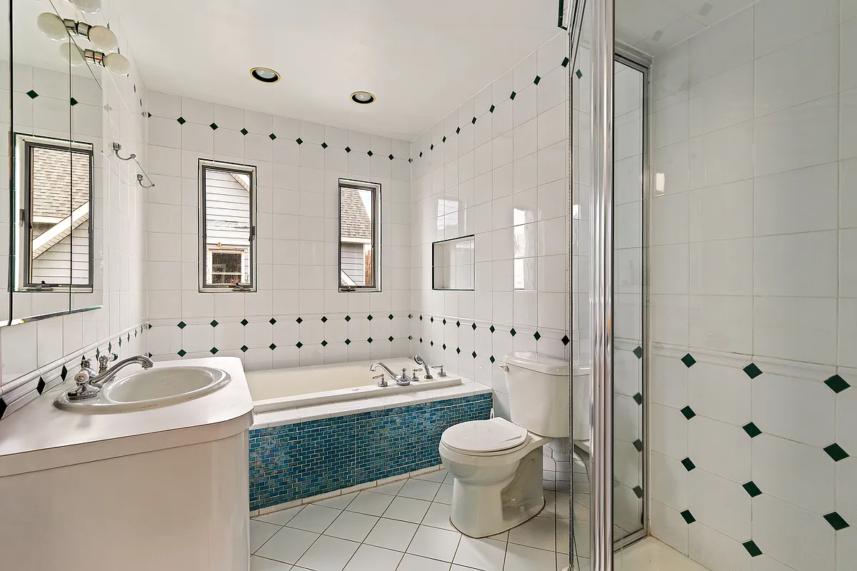 bathroom with corner shower, tub with tile surround