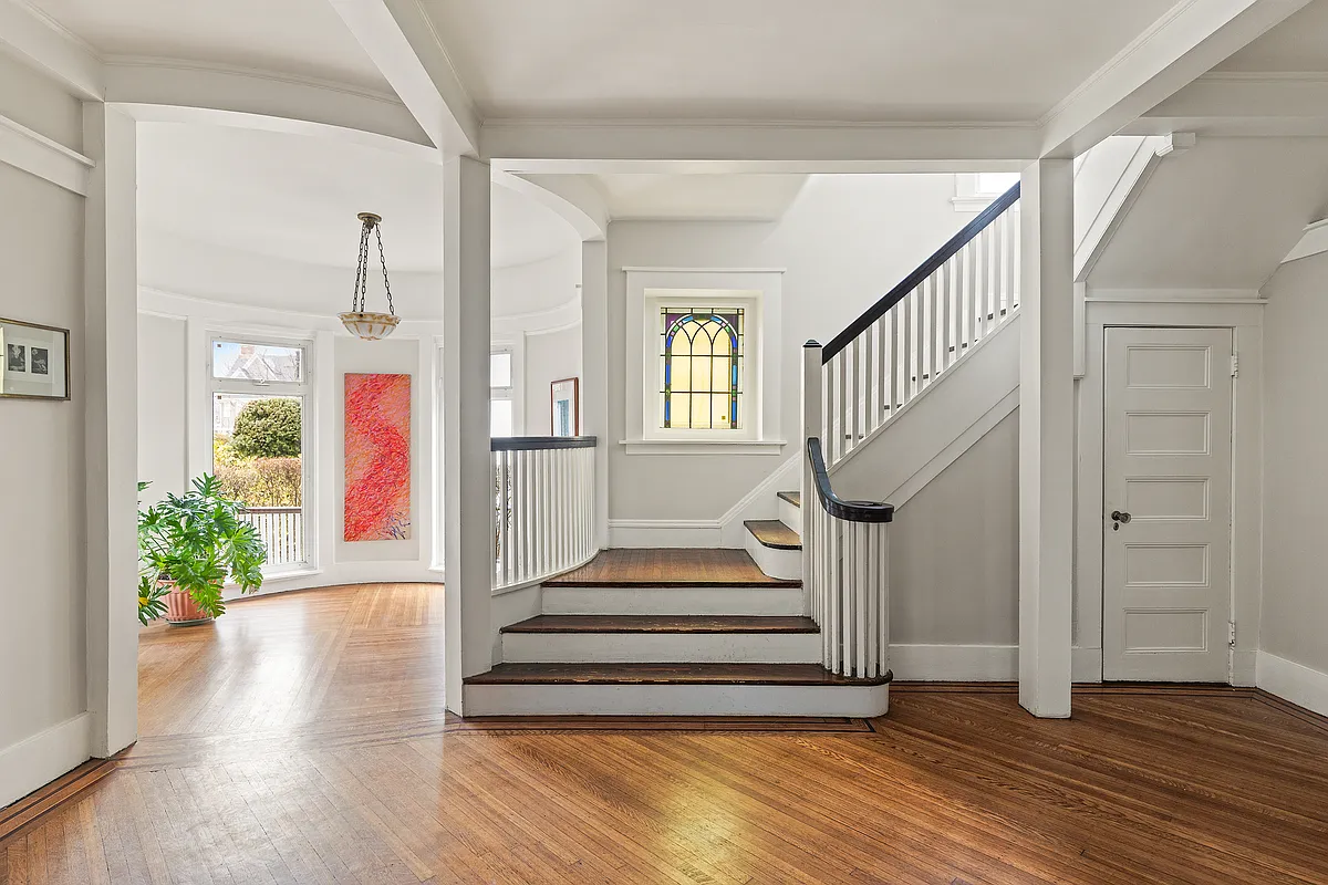 stair hall with stained glass window on landing