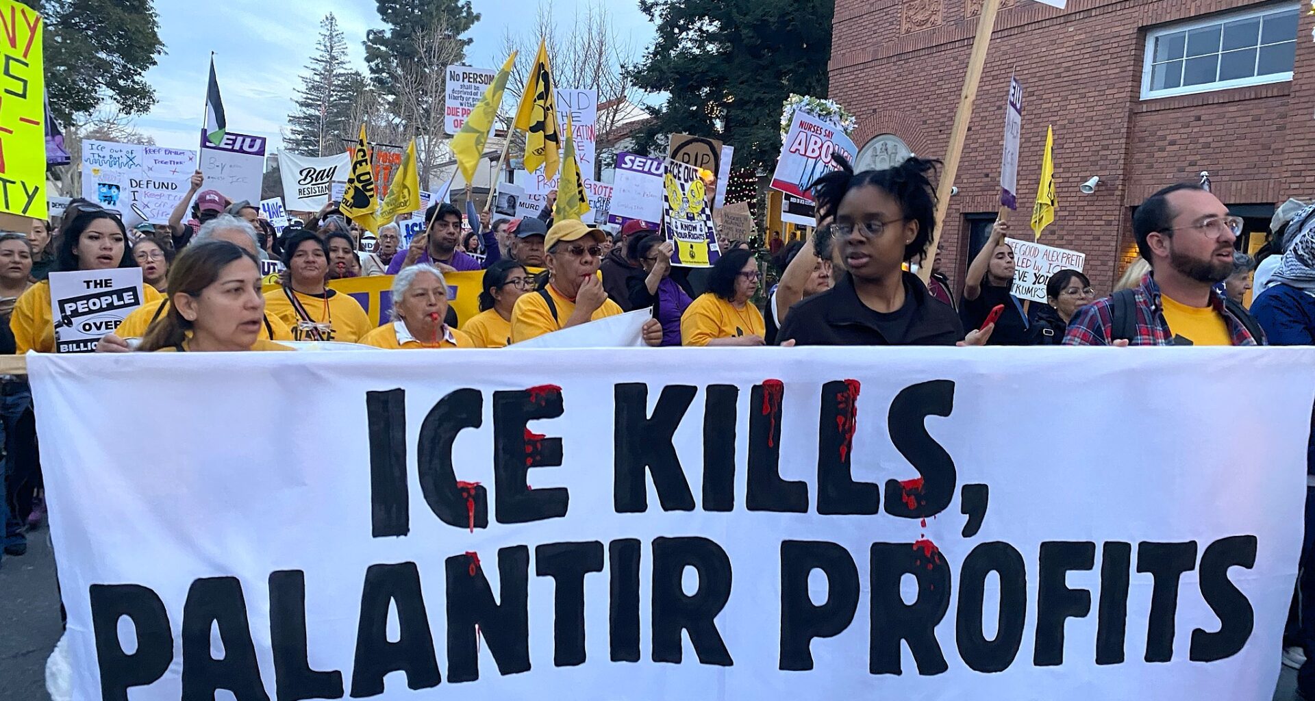 People hold a banner that reads