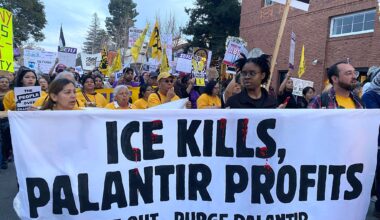 People hold a banner that reads