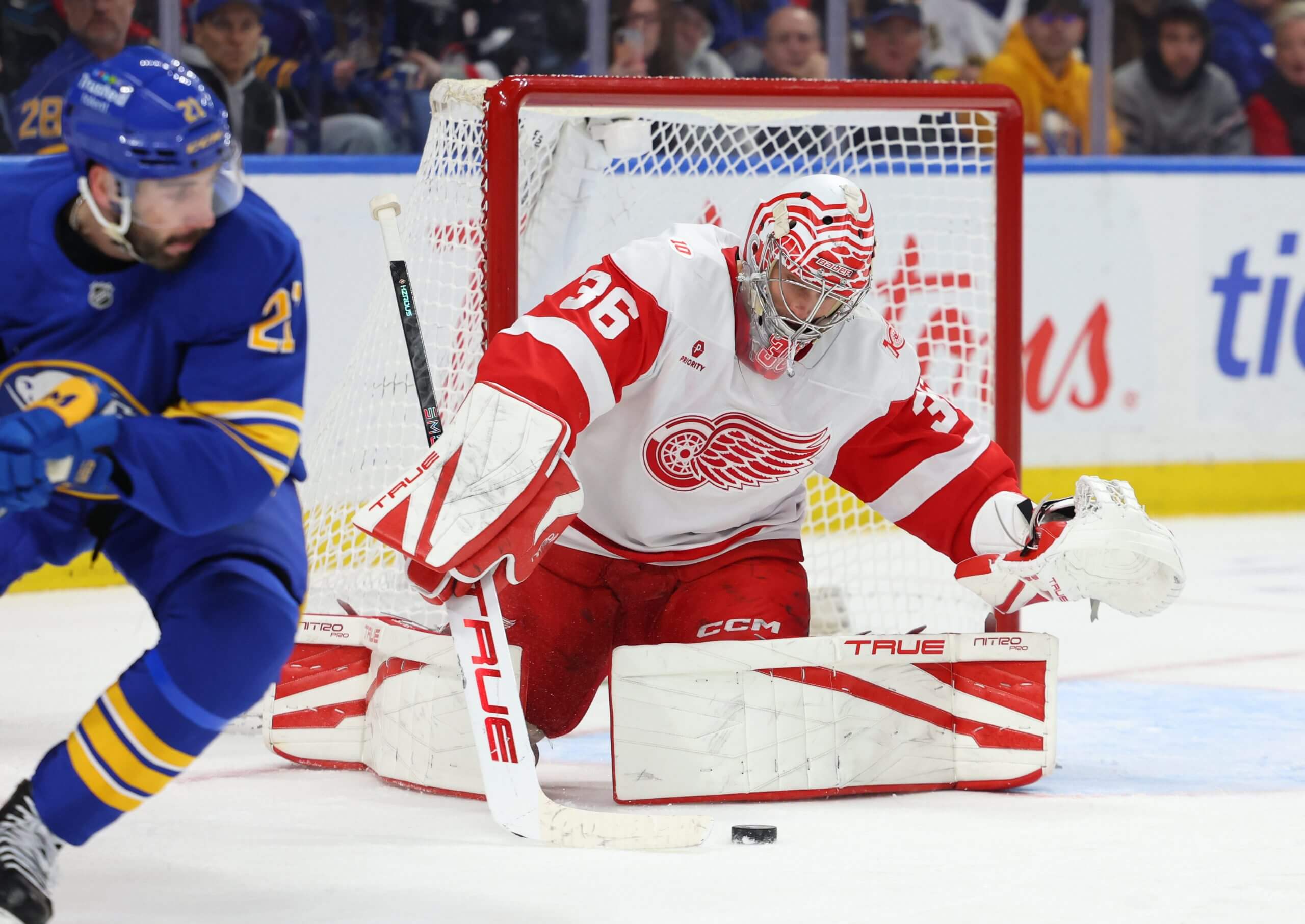 An image of Detroit Red Wings goaltender John Gibson gathering the puck in front of the net during an NHL game.