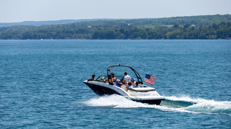 A motorboat cruises over the surface of Skaneateles Lake