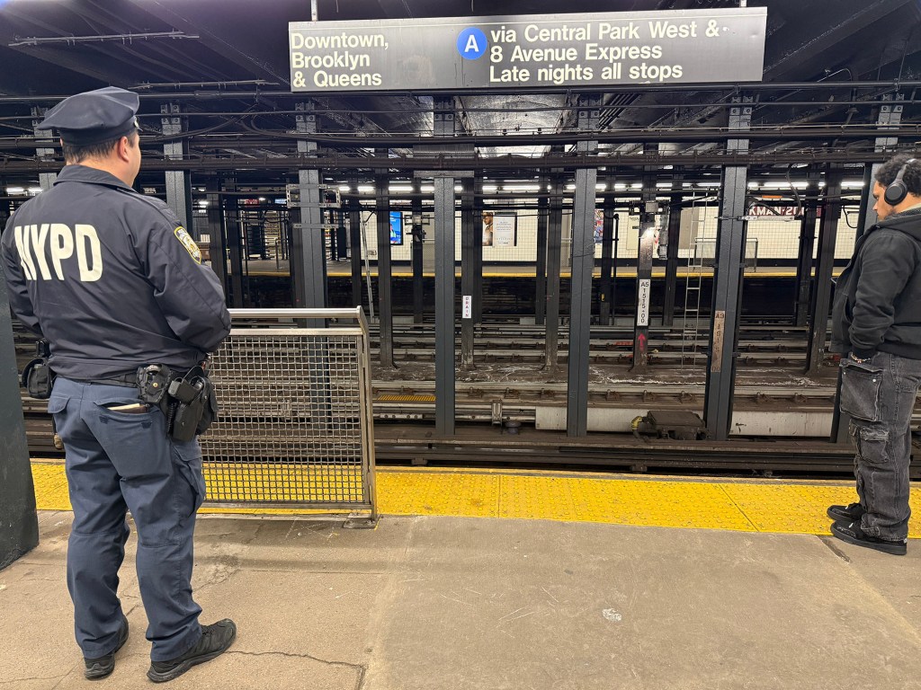 A NYPD officer and a man on a subway platform.