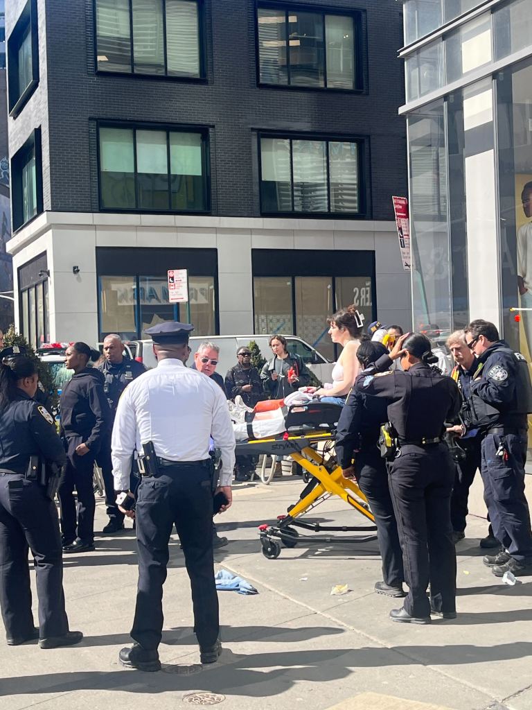 A woman is prepared to be taken to an ambulance after being shot.
