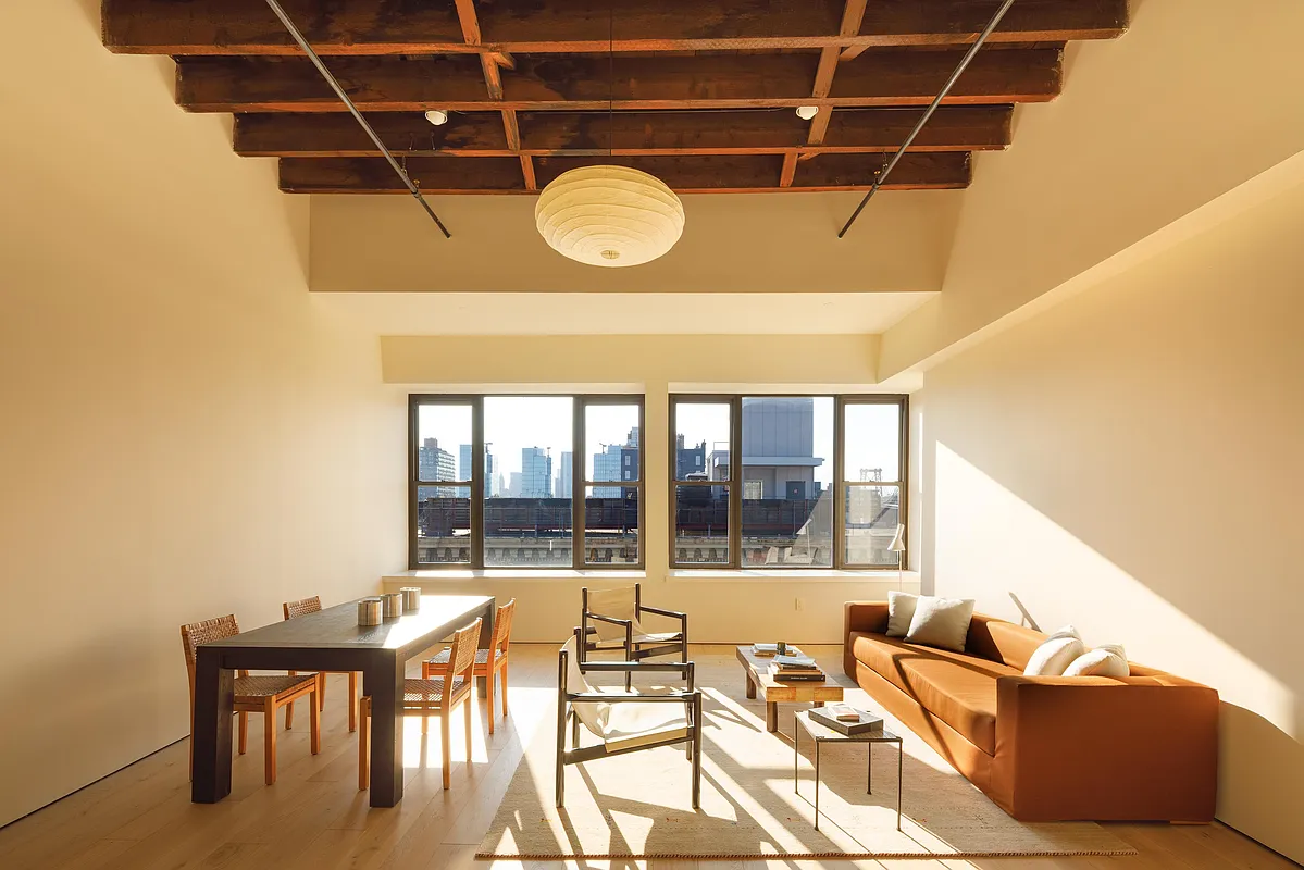 living room with exposed beams, stretch of windows with view of Williamsburg Bridge