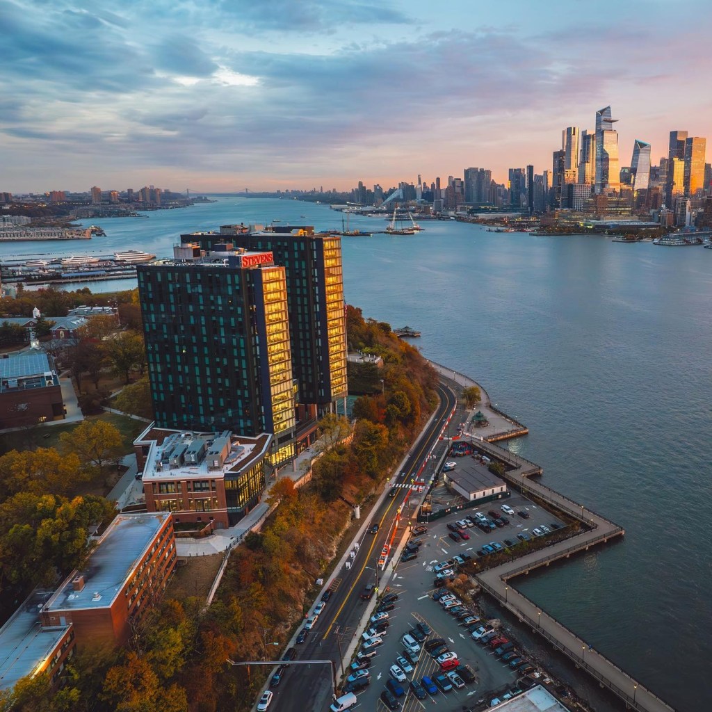 Aerial view of the Stevens Institute of Technology campus and the Hudson River at sunset.