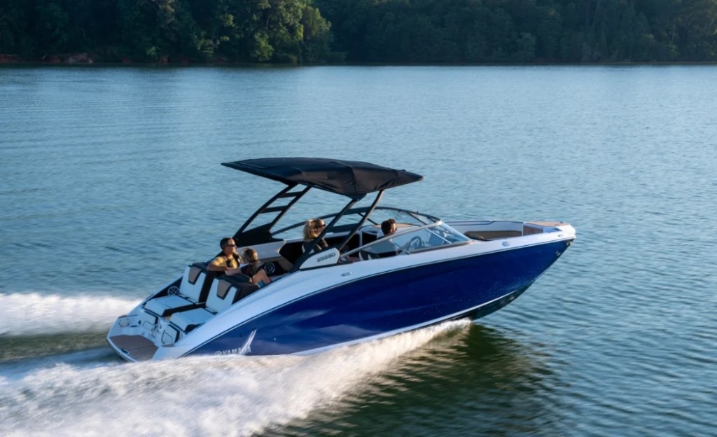 Blue and white Yamaha boat with a black canopy on the water.