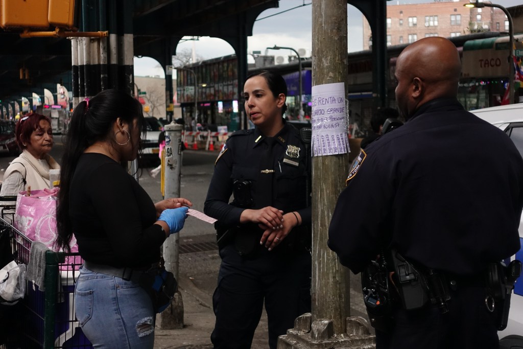 NYPD officers ticket a street vendor in Corona, Queens,