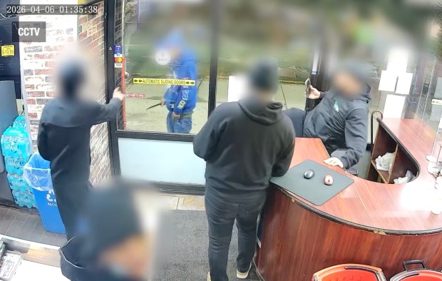 Carlos Santiago is seen brandishing a knife outside the window of the East Harlem grocery store on April 6, 2026.