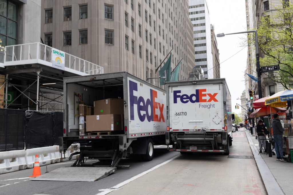 A FedEx delivery truck blocks Broadway in Lower Manhattan, forcing another FedEx truck into the bus lane,