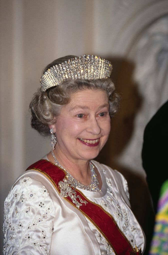 Queen Elizabeth in a tiara smiling with her eyebrows raised