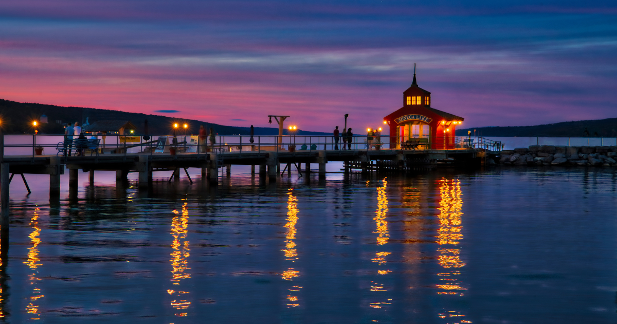 A gazebo on a pier overlooking Seneca Lake at sunset.