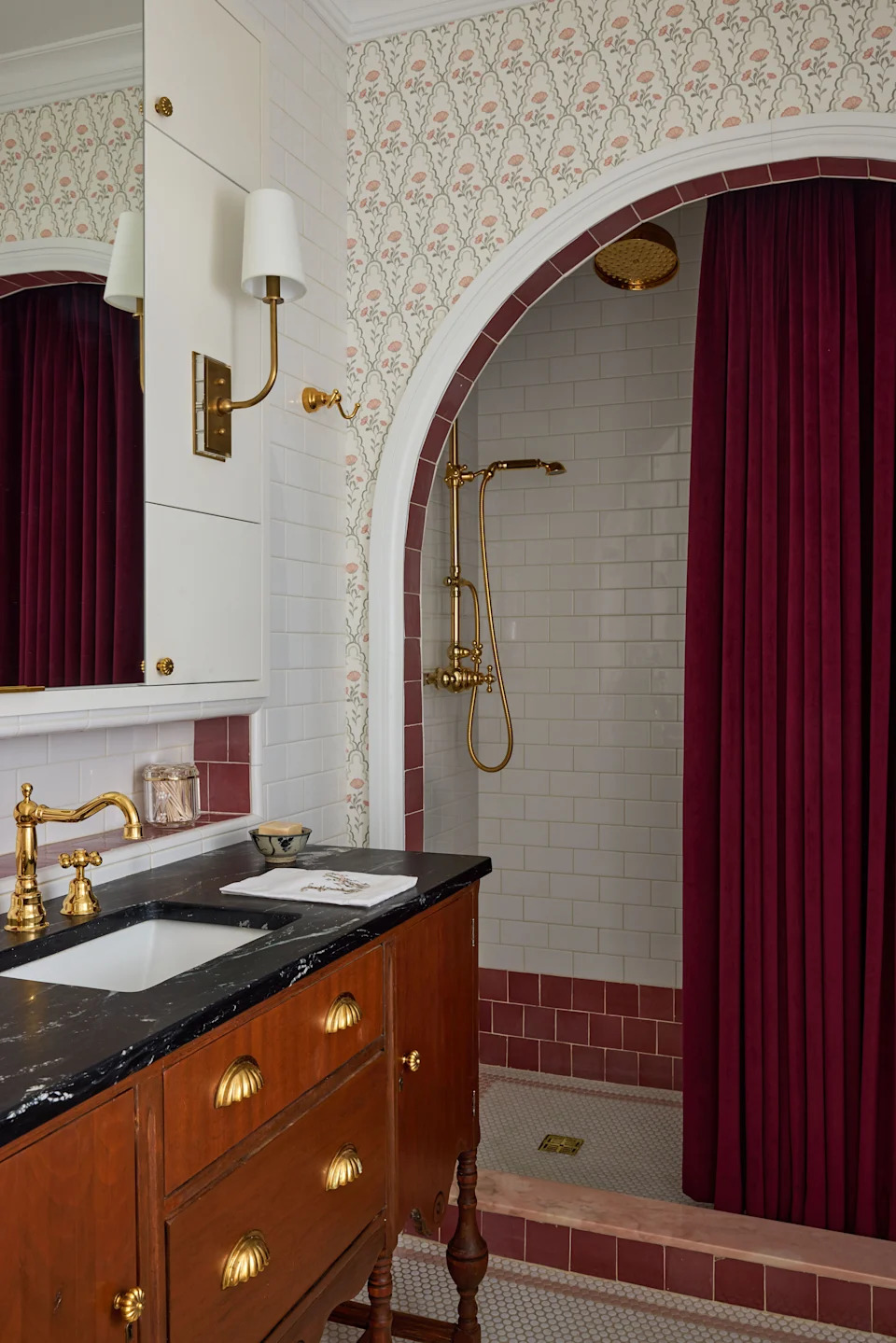 An arched opening frames a shower with House of Rohl fittings, where a velvet curtain from Stout Textiles—“ridiculous in the best way,” Portnof says—adds a note of drama. “I wanted the space to feel like Barrett, and all of the iterations of her, and all the different facets of her brain.”