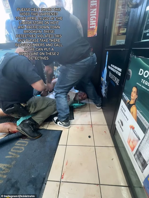 The distressed arrestee is pictured while both detectives lean on his back and cuff him