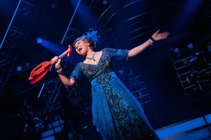 woman in a blue dress appearing on stage, singing