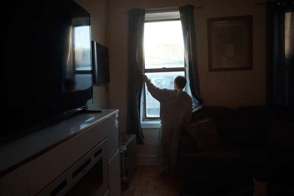 Gulhayo Yuldosheva's son, Heriberto, 11, looks through the window in an apartment building where tenants report maintenance issues and pest infestations, in the Bronx borough of New York, Tuesday, March 17, 2026. (AP Photo/Andres Kudacki)