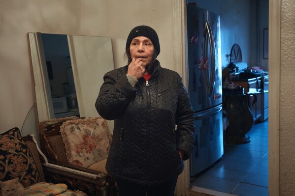 Marina Quiroz stands in her living room in a Bronx apartment building, where tenants report maintenance issues, pest infestations, Tuesday, March 17, 2026, in New York. (AP Photo/Andres Kudacki)
