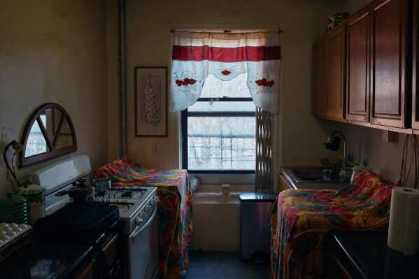 A curtain hangs over the window in Marina Quiroz's kitchen in an apartment building where tenants report maintenance issues and pest infestations, in the Bronx borough of New York, Tuesday, March 17, 2026. (AP Photo/Andres Kudacki)