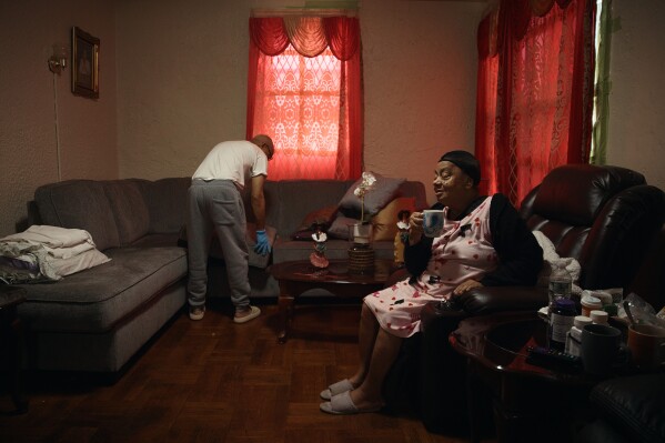 Francisco Medina, left, cleans his apartment next to his relative, Maria Frias, right, in an apartment building where tenants report maintenance issues and pest infestations, in the Bronx borough of New York, Tuesday, March 17, 2026. (AP Photo/Andres Kudacki)