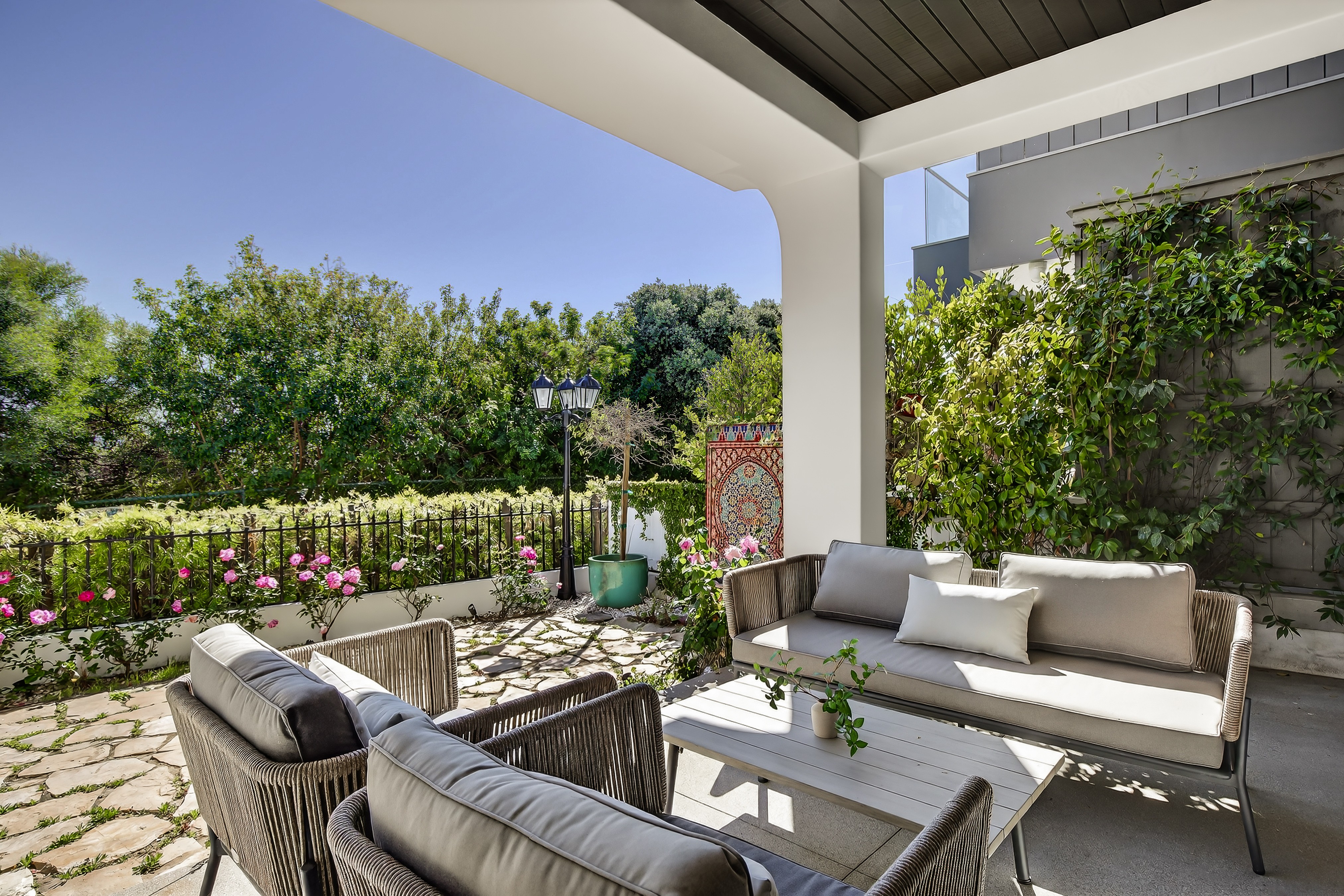 Roses frame the entry patio to this 4,728-square-foot house. (Photo...