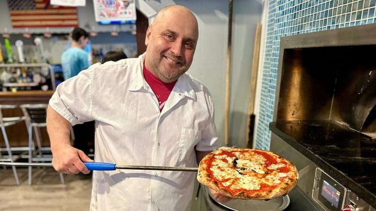 Owner John Zozzaro hefts a Margherita pie at Zozo's on...