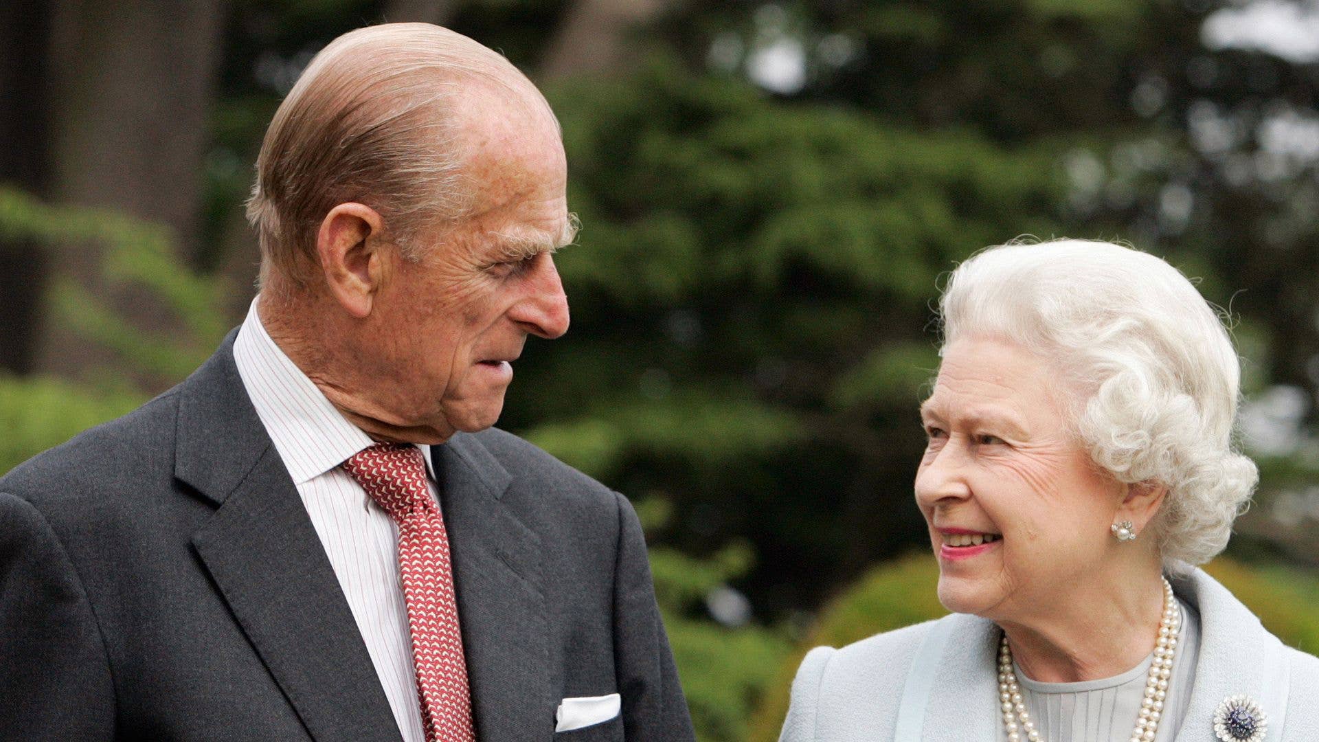 HM The Queen Elizabeth II and Prince Philip smiling at eachother