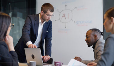 Image of workers in business suits being trained in AI through whiteboard and computer screen