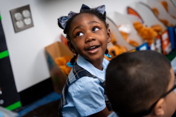 A child smiles during a visit with former President Barack Obama and Mayor Zohran Mamdani at Learning Through Play Pre-K in the Bronx in New York, Saturday, April 18, 2026. (AP Photo/Angelina Katsanis)