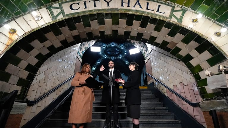 New York Attorney General Letitia James, left, administers the oath...